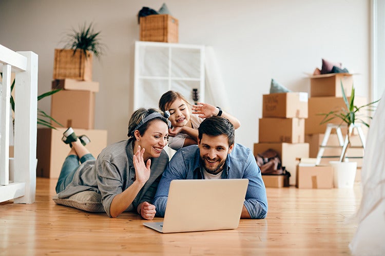 Glückliche Familie winkt während eines Videoanrufs aus der neuen Wohnung