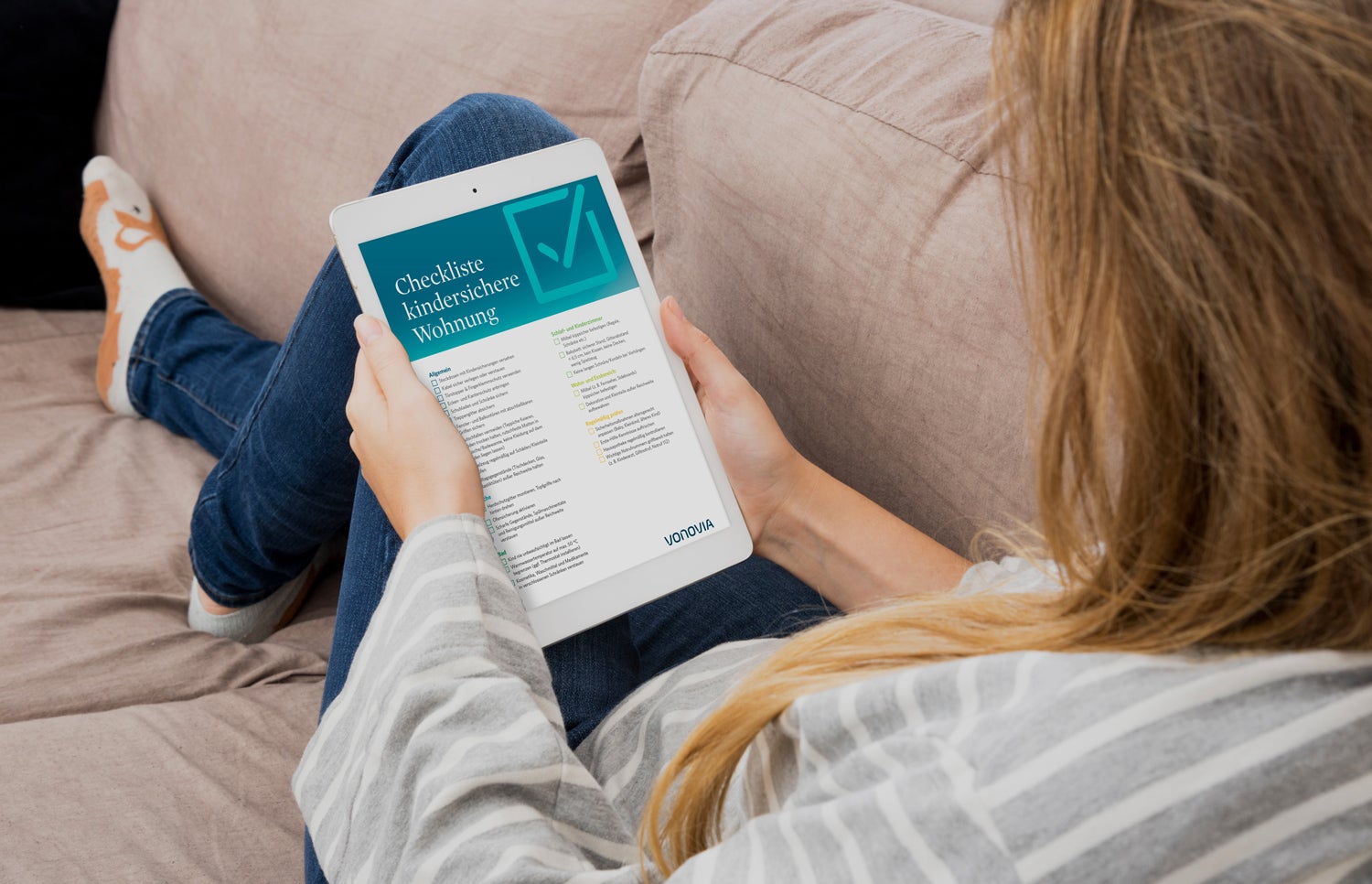 Eine Frau hält ein Tablet mit einer Checkliste in der Hand.